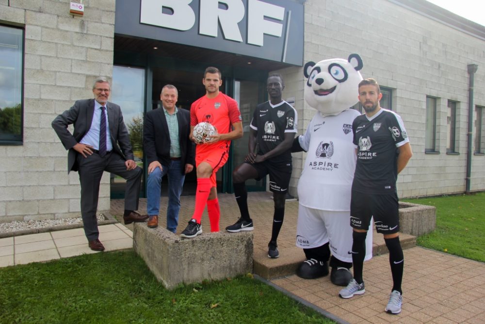 Eine langjährige Partnerschaft: AS Eupen-BRF-MediaConcept (vlnr BRF-Direktor Toni Wimmer, MediaConcept-Geschäftsführer Ewald Broichhausen, Torwart Hendrik Van Crombrugge, Stürmer Mbaye Leye, Maskottchen Eupi und Mittelfeldspieler Luis Garcia)