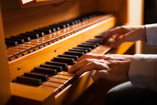 Mann spielt Kirchenorgel