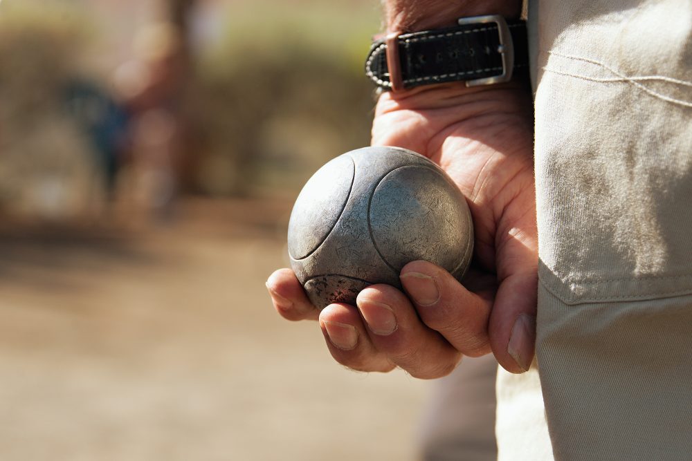 Mann spielt Pétanque