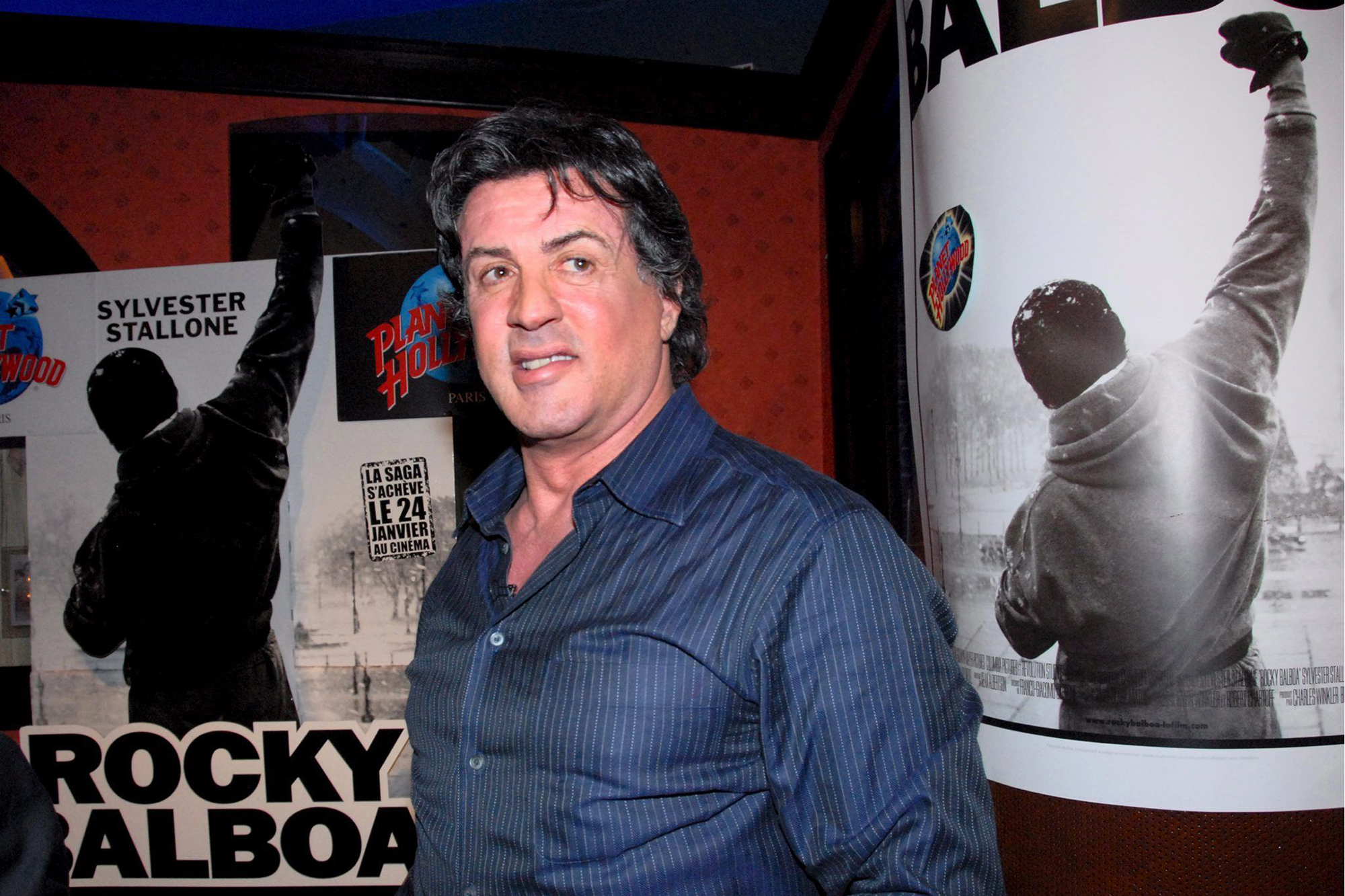 Sylvester Stallone vor Filmplakaten von Rocky Balboa