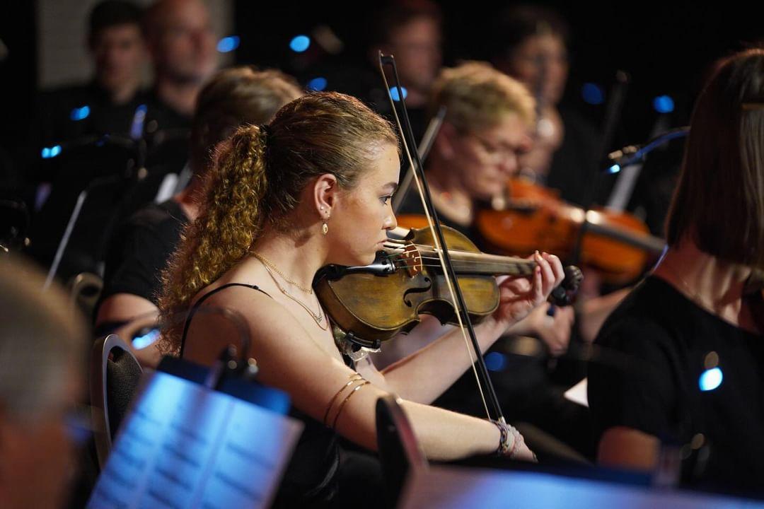 Junge Geigerin spielt in einem Orchester