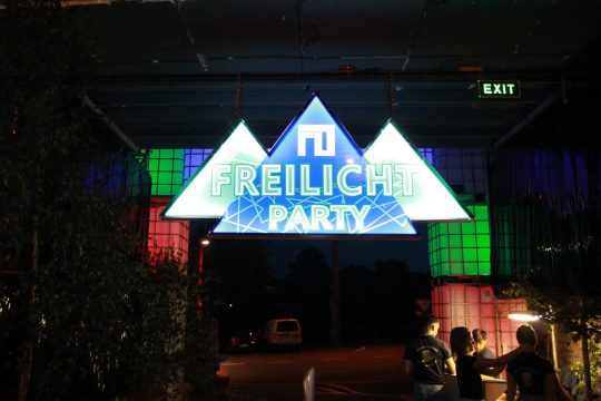 Leuchtschild am Eingang zur Freilichtparty in Deidenberg