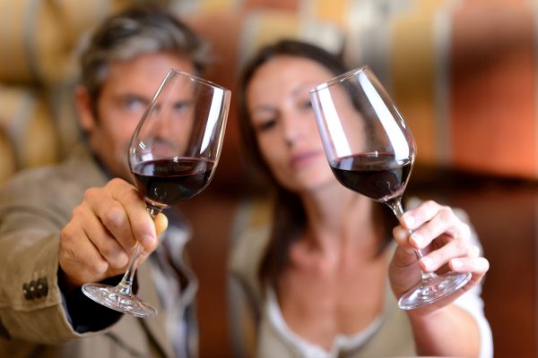 Mann und Frau mit Weingläsern bei einer Weinprobe