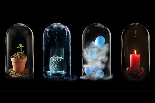 Vier Elemente: Blumentopf mit Erde, Glas mit Wasser, Luftballons und brennende Kerze unter Glaskuppeln