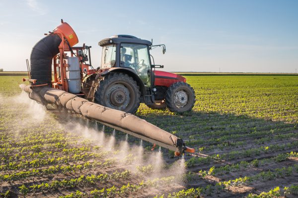Traktor versprüht Pestizide auf einem Feld